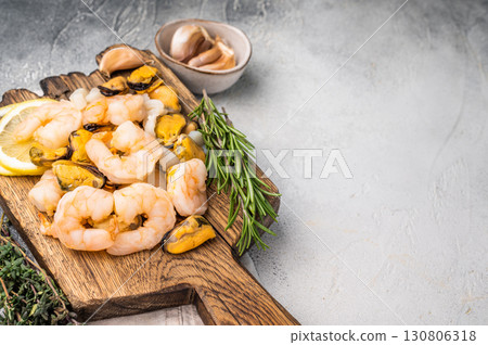 Fresh Seafood cocktail, raw Mix with Mussels, Clams, Prawns, Shrimps and squid on wooden board. white background. top view Fresh Seafood cocktail, raw Mix with Mussels, Clams, Prawns, Shrimps and squid on wooden board. white background. top view 130806318