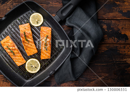 Pan fried salmon fillet steaks with thyme and lemon, fresh fish. wooden background. top view Pan fried salmon fillet steaks with thyme and lemon, fresh fish. wooden background. top view 130806331