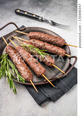 Grilled Cevapcici ready for the grill, roast Cevapi from mince beef meat. grey background. top view 130806347
