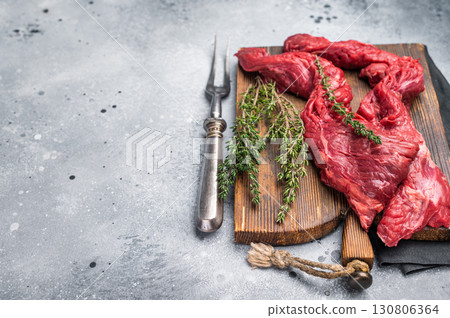 Uncooked Beef Skirt Steak, also name Machete steak, raw meat on cutting board. grey background. top view 130806364
