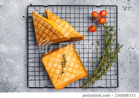 Grilled cheese sandwich on steel rack. grey background. top view Grilled cheese sandwich on steel rack. grey background. top view 130806373