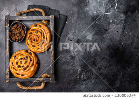 Danish raisin pastry swirls. black background. top view 130806374