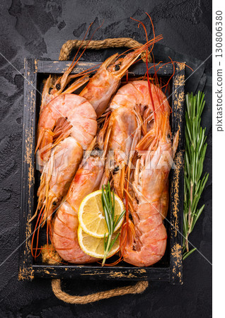 Uncooked raw Red shrimps, Prawns Langostino Austral in wooden tray. black background. top view Uncooked raw Red shrimps, Prawns Langostino Austral in wooden tray. black background. top view 130806380