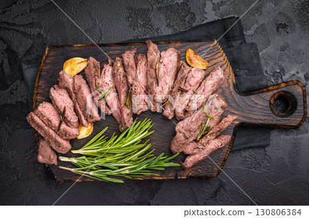 Roast Skirt Machete Steak, grilled beef meat on cutting board. black background. top view Roast Skirt Machete Steak, grilled beef meat on cutting board. black background. top view 130806384