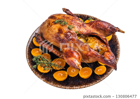 Roast goose with apples and oranges on plate with herbs isolated on white background. top view 130806477