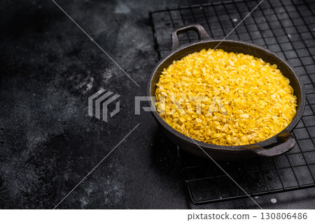 Healthy raw dry Millet flakes for porridge and muesli. black background. top view 130806486