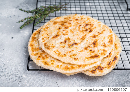 Homemade Kerala wheat paratha, layered parotta. grey background. top view Homemade Kerala wheat paratha, layered parotta. grey background. top view 130806507
