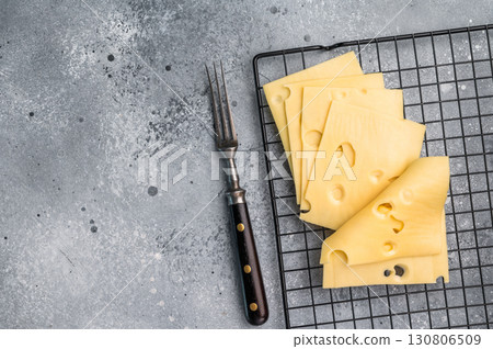 Maasdam cheese slices on kitchen table. grey background. top view 130806509