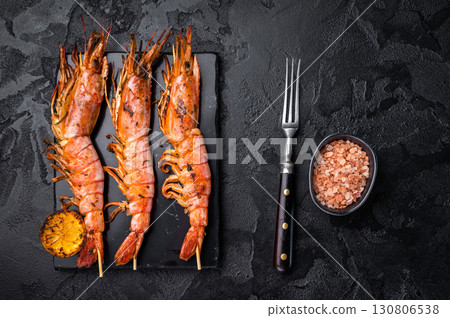 Shrimp kebab, Skewers with Grilled red Prawns Langostino Austral. black background. top view Shrimp kebab, Skewers with Grilled red Prawns Langostino Austral. black background. top view 130806538