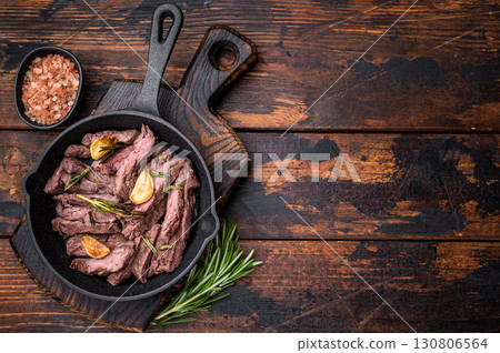Grilled and sliced Beef top sirloin Steak in a pan. wooden background. top view 130806564