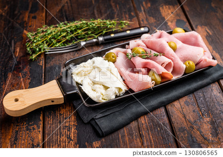 Italian antipasto with Sliced Prosciutto Cotto ham, green olives and mozzarella. wooden background. top view 130806565