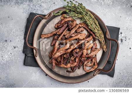 Deep fried beef tender strips, sliced meat in a tray. grey background. top view Deep fried beef tender strips, sliced meat in a tray. grey background. top view 130806569