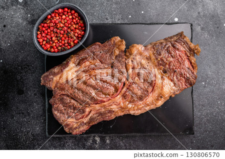Roasted Chuck eye roll steak, marbled beef meat on a board. black background. top view Roasted Chuck eye roll steak, marbled beef meat on a board. black background. top view 130806570