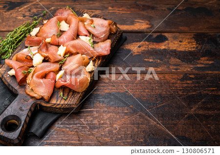 Italian Prosciutto parma ham with herbs and parmesan cheese on wooden board. wooden background. top view Italian Prosciutto parma ham with herbs and parmesan cheese on wooden board. wooden background. top view 130806571