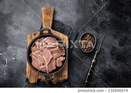 Cooked Boiled lamb meat in a skillet. black background. top view 130806674