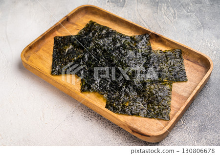 Crispy Nori seaweed sheets in a wooden tray. white background. top view 130806678