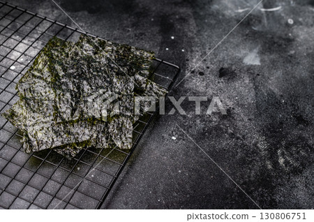 Dried Nori seaweed sheets on a rack. black background. top view Dried Nori seaweed sheets on a rack. black background. top view 130806751