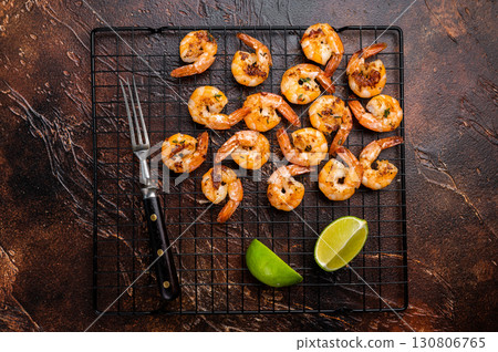 Grilled Shrimps Prawns with garlic on a rack. Brown background. Top view Grilled Shrimps Prawns with garlic on a rack. Brown background. Top view 130806765