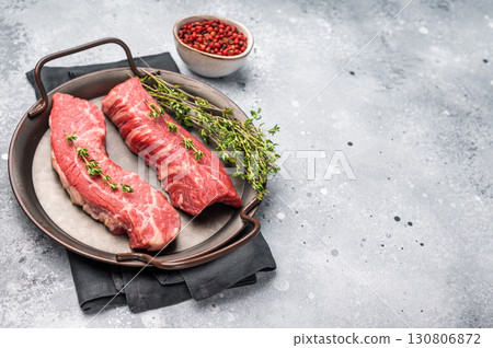 Raw Tri Tip Steak from Black Angus beef meat in stell tray. grey background. top view 130806872