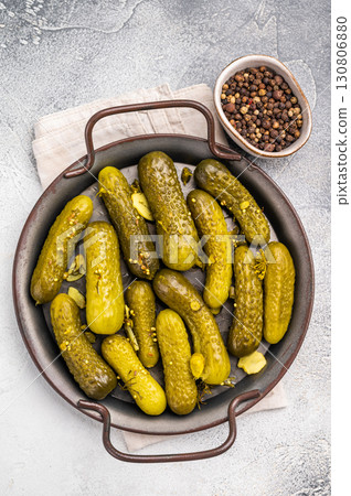 Freshly jarred dill pickles, a delightful addition to any meal or charcuterie board that adds a zesty crunch. grey background. top view 130806880