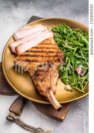 Mouthwatering grilled pork chop with a stunning presentation, perfect for serving at special occasions. grey background. top view 130806899