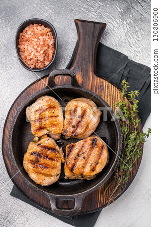 Juicy grilled pork medallions steaks, perfectly seared tenderloin meat for a flavorful bite, ideal for any gourmet meal. grey background. top view Juicy grilled pork medallions steaks, perfectly seared tenderloin meat for a flavorful bite, ideal for any gourmet meal. grey background. top view 130806900