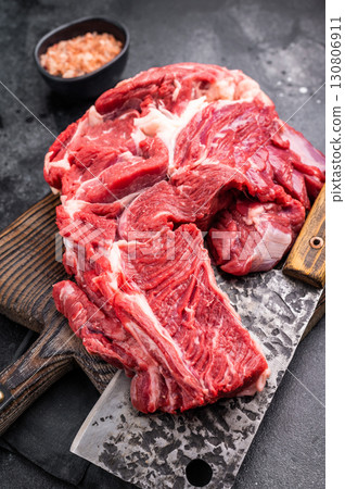 Beautifully marbled raw beef neck meat, perfect for enhancing your favorite recipes with rich flavors. black background. top view Beautifully marbled raw beef neck meat, perfect for enhancing your favorite recipes with rich flavors. black background. top view 130806911