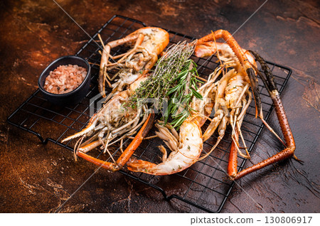 Savory grilled rosenbergii prawn drizzled with garlic butter, a luxurious treat for any seafood enthusiast. brown background. top view Savory grilled rosenbergii prawn drizzled with garlic butter, a luxurious treat for any seafood enthusiast. brown background. top view 130806917