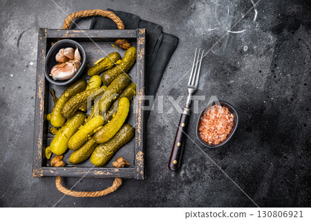 Sweet and tangy pickled cucumbers, ideal for enhancing burgers and wraps with a burst of flavor. black background. top view 130806921
