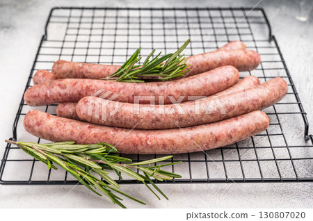 Fresh raw sausage links ready for grilling, perfect for barbecues or hearty family meals..white background. top view Fresh raw sausage links ready for grilling, perfect for barbecues or hearty family meals..white background. top view 130807020