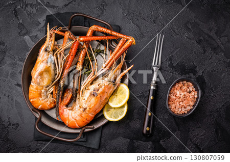 Succulent grilled rosenbergii prawn shrimp, perfectly charred and bursting with flavor, ideal for seafood lovers. black background. top view Succulent grilled rosenbergii prawn shrimp, perfectly charred and bursting with flavor, ideal for seafood lovers. black background. top view 130807059