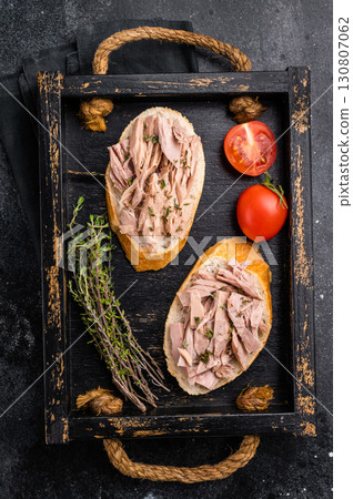 Gourmet style tuna sandwich with fresh herbs and spices, elevating your lunchtime experience to the next level. black background. top view Gourmet style tuna sandwich with fresh herbs and spices, elevating your lunchtime experience to the next level. black background. top view 130807062