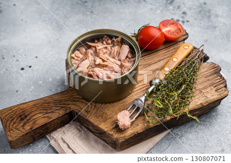 Delicious canned tuna in olive oil, ideal for salads, sandwiches, or as a savory snack on the go. grey background. top view Delicious canned tuna in olive oil, ideal for salads, sandwiches, or as a savory snack on the go. grey background. top view 130807071
