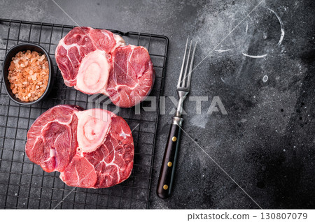 Fresh raw ossobuco Premium veal shank, ideal for slow cooking and creating hearty, comforting meals that impress. black background. top view 130807079