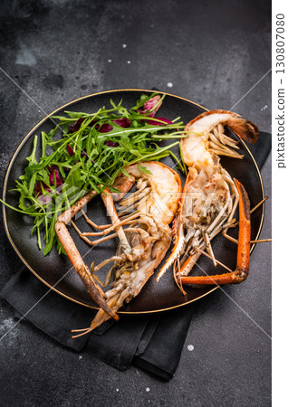 Elegant plate of grilled rosenbergii prawns shrimps garnished with fresh herbs, perfect for gourmet dining experiences. black background. top view Elegant plate of grilled rosenbergii prawns shrimps garnished with fresh herbs, perfect for gourmet dining experiences. black background. top view 130807080