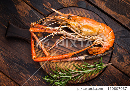 Juicy grilled giant river prawn shrimp served with rosemary, a mouthwatering dish for your next barbecue. wooden background. top view 130807087