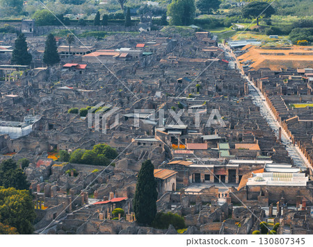 Aerial view of Pompeii's ancient ruins in Italy, showing grid like streets, stone buildings, courtyards, and surrounding greenery from above. Aerial view of Pompeii's ancient ruins in Italy, showing grid like streets, stone buildings, courtyards, and surrounding greenery from above. 130807345