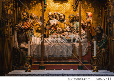 Intricate altarpiece depicting a central figure on a bed, surrounded by expressive figures, framed by ornate gold and wood in a Frankfurt cathedral. 130807611