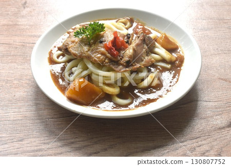 slice roasted chicken topping udon or Japanese rice noodles dressing potato and carrot in Japanese curry on plate  130807752