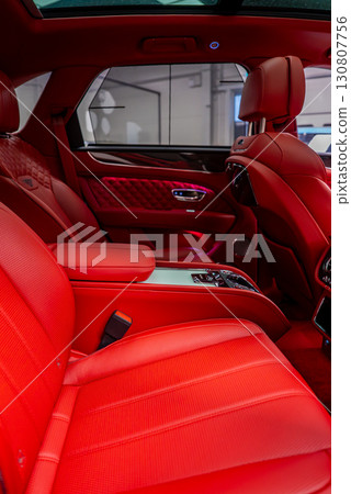 Close up of a Bentley Bentayga interior featuring red leather upholstery, diamond stitching, a panoramic sunroof, and polished metallic accents. Close up of a Bentley Bentayga interior featuring red leather upholstery, diamond stitching, a panoramic sunroof, and polished metallic accents. 130807756