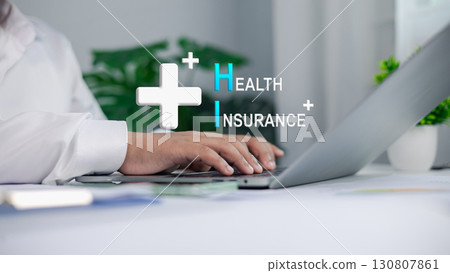 Businessman working on laptop with health insurance concept and medical cross icon Businessman working on laptop with health insurance concept and medical cross icon 130807861