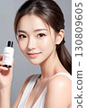 拿著化妝品瓶的年輕女子 130809605