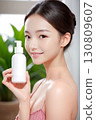 拿著化妝品瓶的年輕女子 130809607