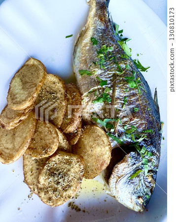 Grilled sea bream fish with potato chips. Tasty and healthy food. 130810173