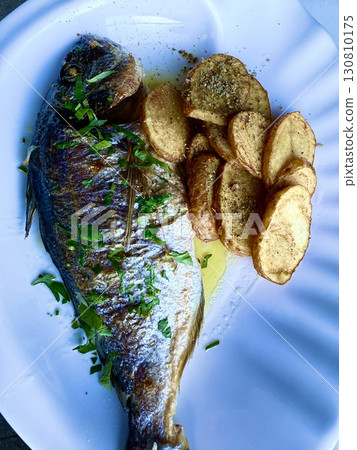 Grilled sea bream fish with potato chips. Tasty and healthy food. 130810175