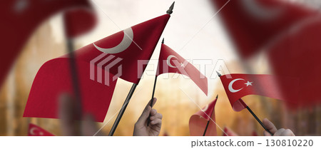Turkey flags in their hands on a blurred urban background 130810220