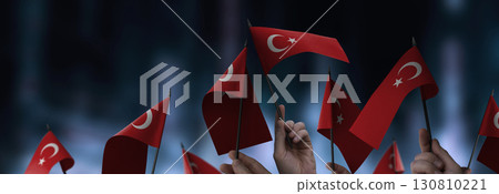 Turkey flags in their hands on a blurred urban background 130810221