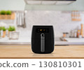 Modern air fryer appliance on kitchen countertop with blurred background 130810301