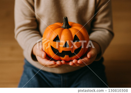 Hand holding a jack-o'-lantern 130810308