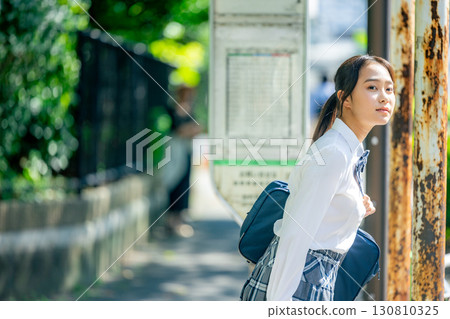 High school students waiting for the bus at the bus stop High school students waiting for the bus at the bus stop 130810325